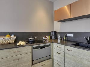 a kitchen with a stove and a sink at Aparthotel & Spa Adagio Vannes in Vannes