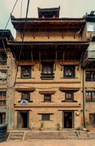 an old building with windows on the side of it at Manju Baha Hotel in Bhaktapur