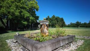 a garden with a tree stump fountain in a park at Casa Rifugio Parma in Basilicanova