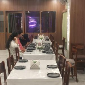 a group of people sitting at a long table at Hotel ashtha inn in Gaya +7 photos