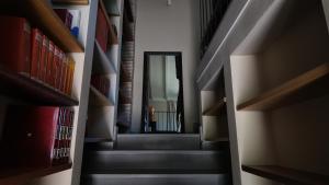 a hallway with a staircase with books at Casa Rifugio Parma in Basilicanova