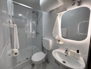 a white bathroom with a toilet and a sink at Apartments Bernarda 1 in Nin