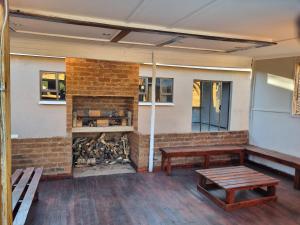 a room with benches and a brick fireplace at Sunflower Acres in Kimberley
