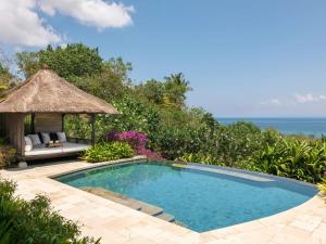 a swimming pool with a gazebo and the ocean at Raffles Bali in Jimbaran +155 photos