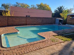 a swimming pool with a brick retaining wall and a brick at Sunflower Acres in Kimberley