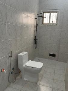 a bathroom with a white toilet and a shower at Mitty Residence in Conakry