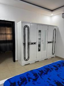a room with white cabinets and a blue rug at Mitty Residence in Conakry