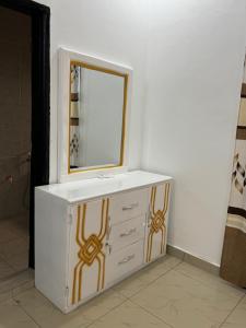 a white bathroom sink with a mirror on it at Mitty Residence in Conakry +4 photos
