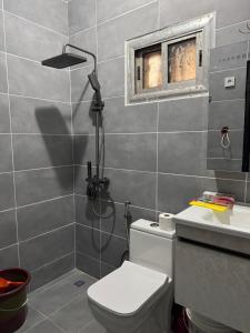 a bathroom with a shower and a toilet and a window at Mitty Residence in Conakry