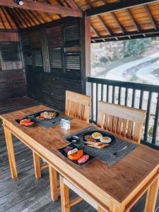 a wooden table with plates of food on it at The SUN House in Balian