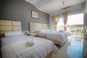 a hotel room with two beds and a balcony at Villa Velzon Lux in Budva