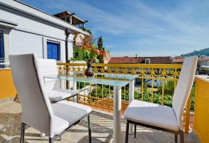 a patio with a glass table and chairs on a balcony at Villa Velzon Lux in Budva
