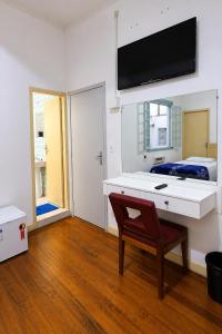 a room with a desk and a bed with a television at Hotel Internacional São Paulo in São Paulo