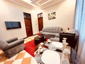a living room with two couches and a tv at Makali Private Villa- 2En-Suite Bedrooms in Arusha