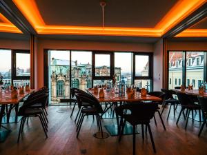 a dining room with tables and chairs and large windows at Staycity Aparthotels Dresden City Centre in Dresden