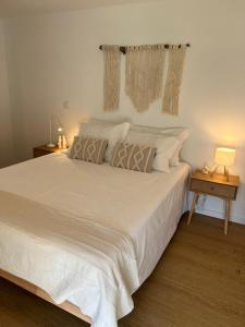 a bedroom with a large white bed with pillows at Refúgio do Saltadouro - Entre o Gerês e a Cabreira in Ruivãis