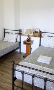 a room with two beds and a table with a lamp at Rosalie Home - Aegean Deck in Tinos