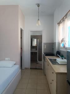 Eine weiße Küche mit Bett und Spüle in der Unterkunft Sunshine Studios in Mylopotas + 145 Fotos