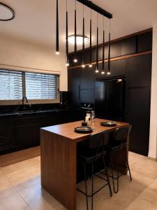 a kitchen with a large island with bar stools at Villa Naama in Qasrîne