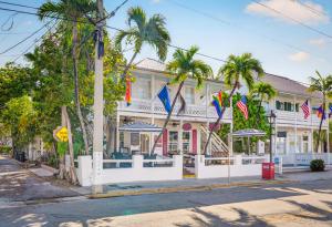 a large white building with palm trees in front of it at BOOTLEGGER BAY @ Speakeasy Inn Key West! in Key West