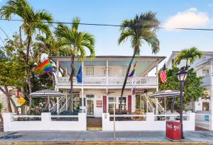 a white building with palm trees in front of it at BOOTLEGGER BAY @ Speakeasy Inn Key West! in Key West +3 photos