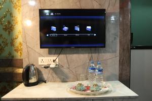 a television on a wall with a plate of food and water bottles at Hotel Royal Sen in Lālbhitti +50 photos