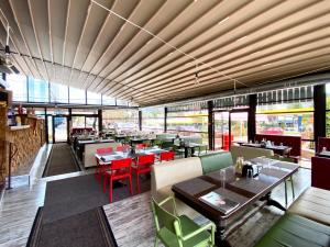a dining room with tables and chairs and windows at Vila Predeal Holidays in Predeal