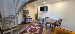 a living room with a table and chairs and a staircase at Altes Saale Fährhaus in Naumburg