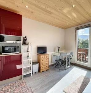 a room with a kitchen with a table and a window at Studio montagne Les Carroz in Arâches-la-Frasse