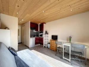 a living room with a couch and a kitchen at Studio montagne Les Carroz in Arâches-la-Frasse +2 photos