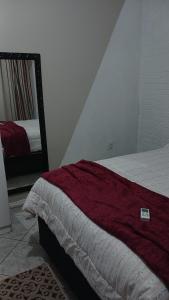 a bedroom with a bed and a mirror at Casa Napolitana in Uruguaiana
