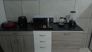 a kitchen counter with a microwave and a coffee maker at Casa Napolitana in Uruguaiana