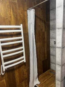 a white shower curtain in a room with a wooden floor at Апартаменти La Familia в Одеський Бульвар - Od 433 in Teremki