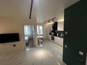 a living room with a television and a kitchen at Апартаменти La Familia в Одеський Бульвар - Od 433 in Teremki