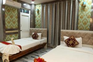 a bedroom with two beds and a window at Hotel Royal Sen in Lālbhitti
