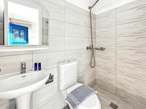 a white bathroom with a toilet and a sink at Stavros Beachfront Domes by Booking Kottas in Perivolos