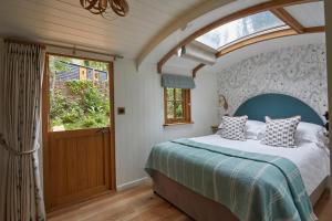 a bedroom with a bed and a large window at The Fish Hotel in Broadway