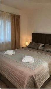 a bedroom with a large bed with two towels on it at Villa BESA - BA Debar in Debar