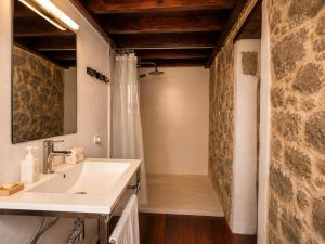 a bathroom with a sink and a stone wall at Casa Luna - Agüimes in Agüimes +26 photos