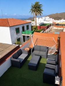 a patio with couches on the roof of a building at Casa Luna - Agüimes in Agüimes