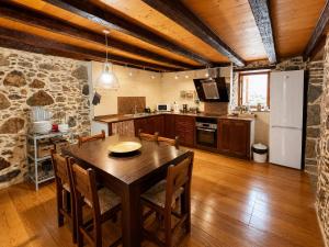 a kitchen and dining room with a wooden table and chairs at Casa Luna - Agüimes in Agüimes