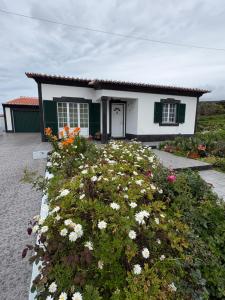 a small house with flowers in front of it at Zizi home in Biscoitos