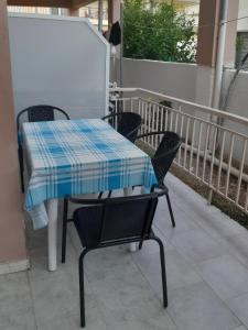 a table and chairs with a blue and white checkered at Irini rooms Olympiada in Olympiada