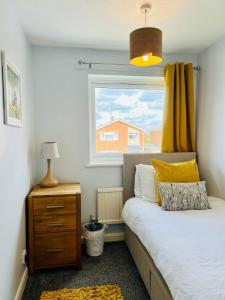 a bedroom with a bed and a window at Bright & Sociable Home with Garden Retreat in Capel Saint Mary