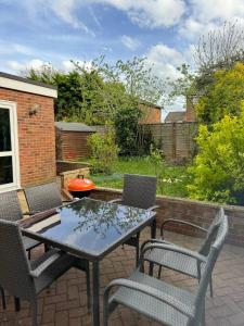 a patio with a table and chairs on a patio at Bright & Sociable Home with Garden Retreat in Capel Saint Mary