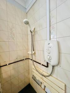 a shower in a bathroom with aige tiled wall at Bright & Sociable Home with Garden Retreat in Capel Saint Mary +74 photos