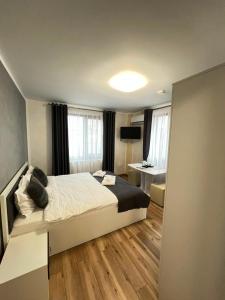 a bedroom with a large bed and a desk at Hotel Palas Grand View in Iaşi