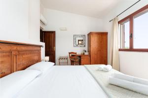 a white bedroom with a large bed and a desk at Sa Murta Bianca Guesthouse Budoni in Budoni +37 photos