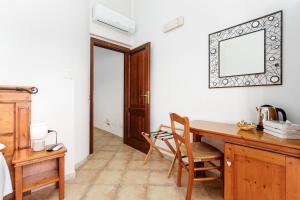 a room with a desk and a mirror on the wall at Sa Murta Bianca Guesthouse Budoni in Budoni