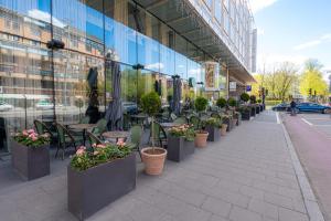 a row of tables and chairs and potted plants on a sidewalk at Clarion Hotel Stockholm in Stockholm
